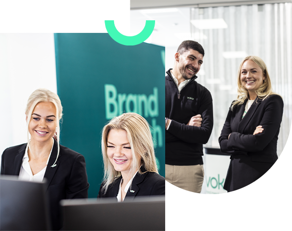 Fyra Voky-anställda. Två står fokuserade vid en dator, medan två andra ler och har armarna i kors.